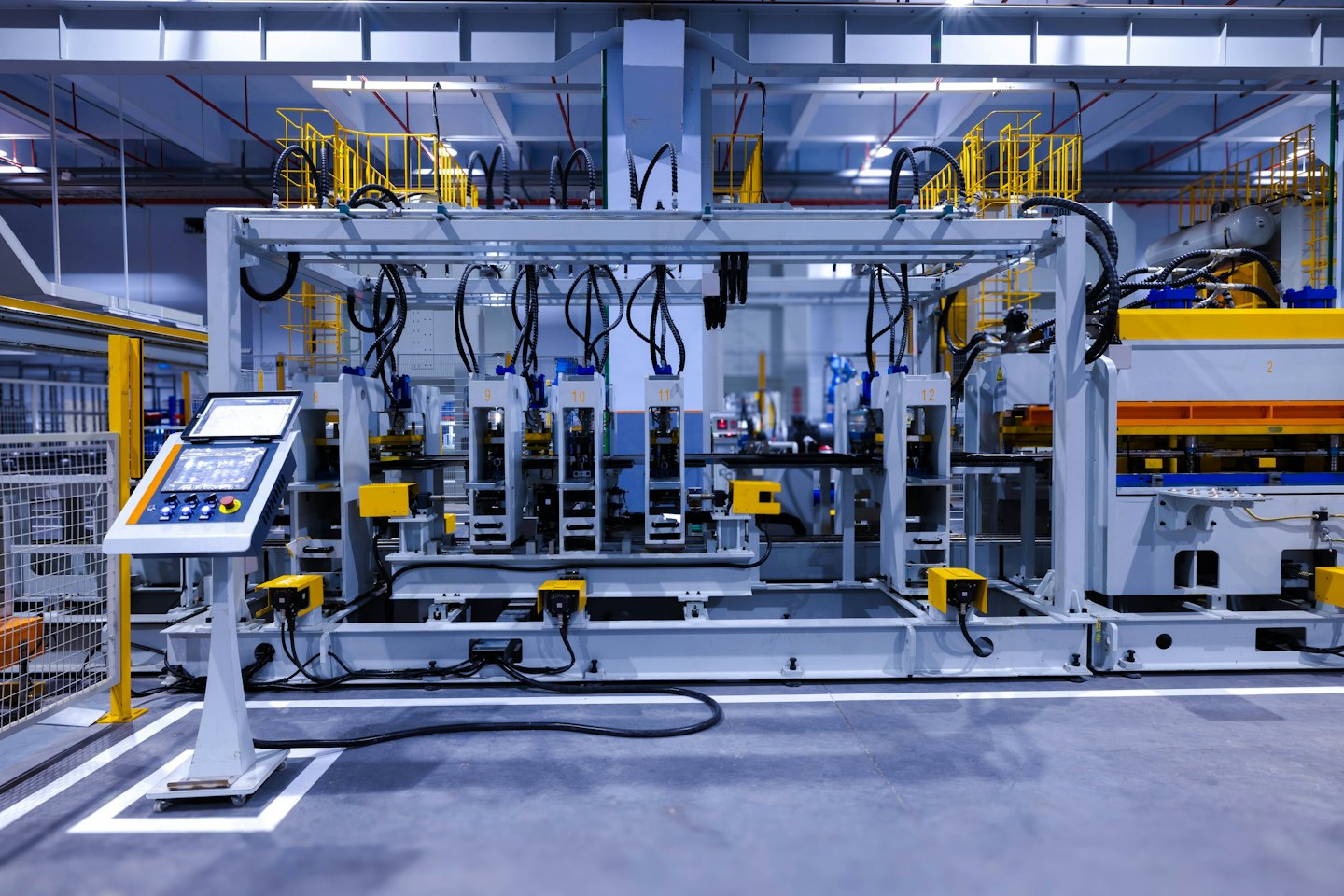 Automated robotic arms working on a machine in a factory.